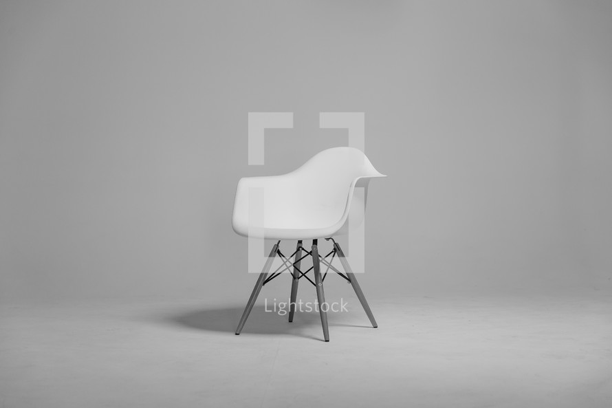 A plastic white chair in an empty room.