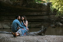 couple sitting outdoors by a river 