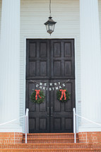 Merry Christmas banner and wreaths on church doors 