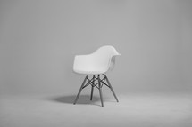 A plastic white chair in an empty room.