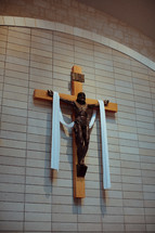 Draped crucifix on a brick wall.
