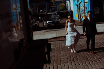 bride and groom on a cobble stone street 