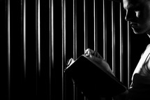 a man reading a Bible in prison 