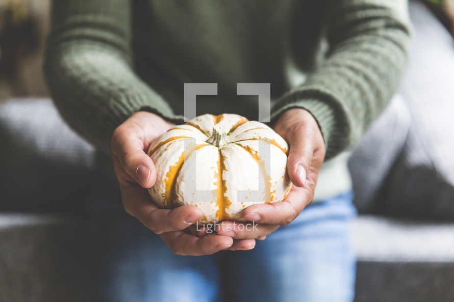 a woman holding a pumpkin 