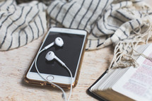scarf, earbuds, cellphone, and open Bible 