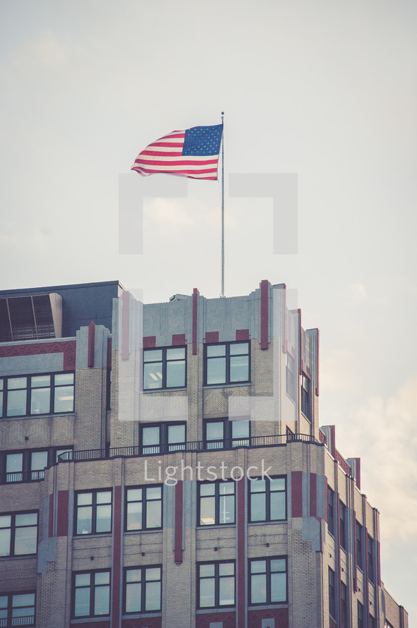 American flag at the top of a tall building 