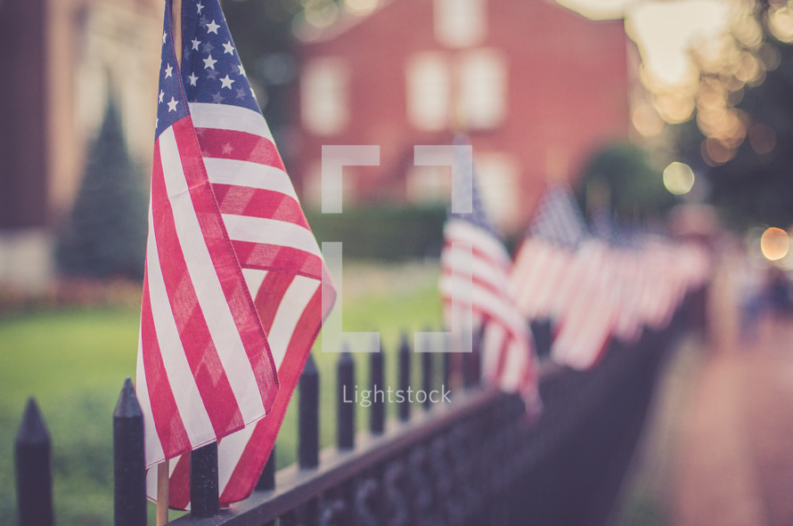 American flags along a fence 