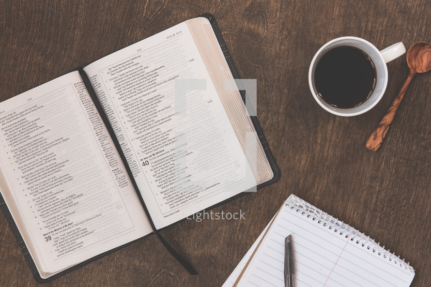 open Bible, notepad, pen, Bible study, coffee mug, spoon 