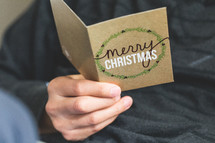 a man reading a Christmas greeting card 