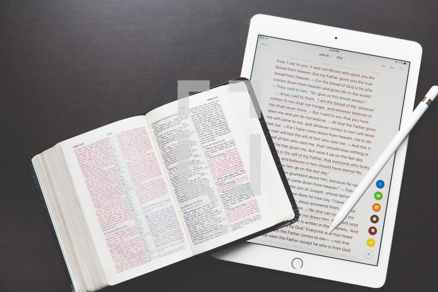 An open Bible and an electronic tablet.