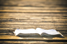 Open Bible on a wooden deck.