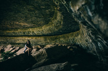 woman squatting in a cave 