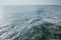 men wading in the ocean 
