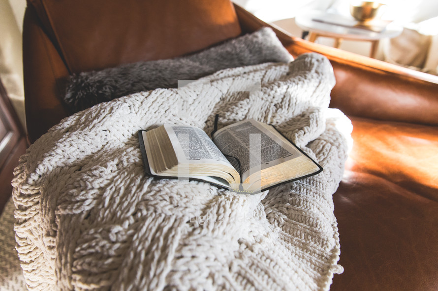 open Bible on a blanket in a chair 
