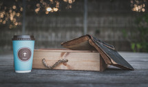 coffee cup with cross on wood ledge with Bible and wood box 