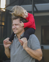 toddler girl on father's shoulders