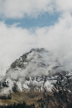 snow capped mountain peaks in the clouds 