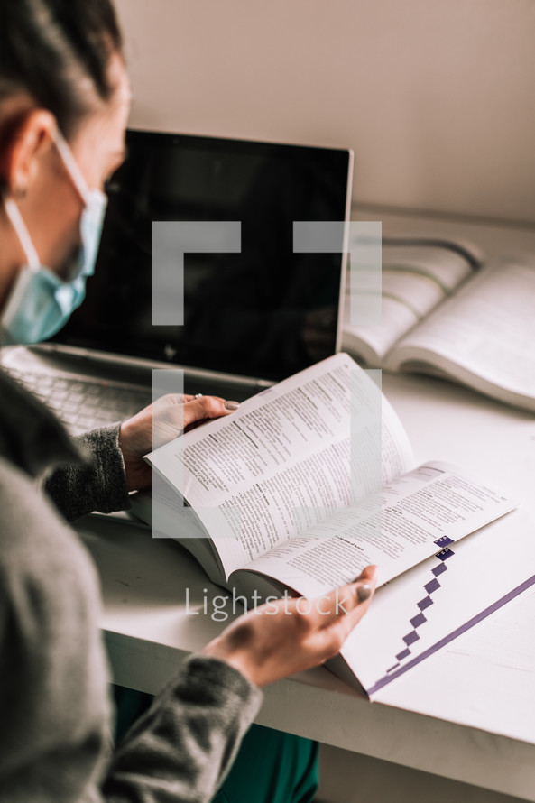 doctor sitting at a desk reading a Bible 