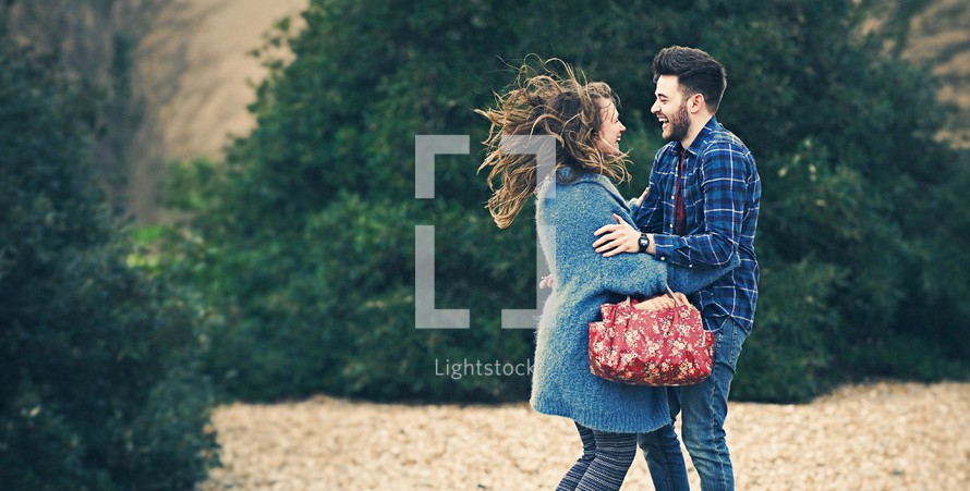 a happy young couple bouncing around outdoors 
