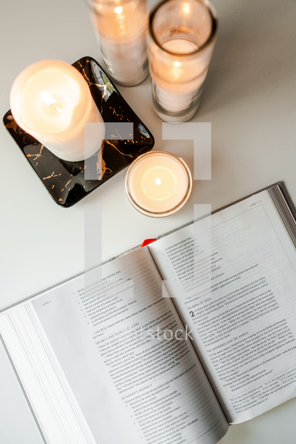 candles and pages of a Bible study book 