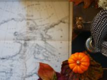  vintage map, desk, fall leaf and mini pumpkin on a leather bound book 