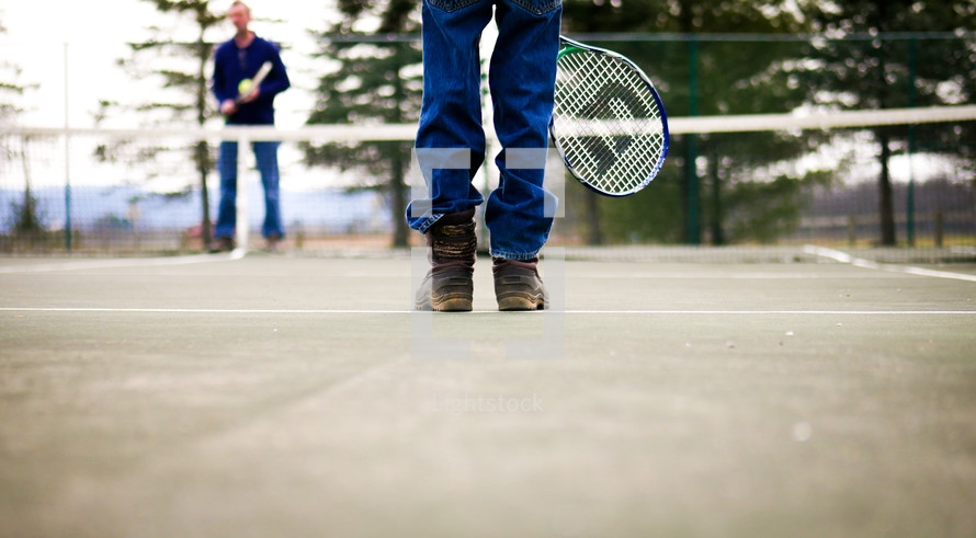 people standing on a tennis court in jeans 