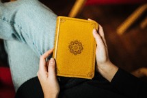 a woman holding a Bible in her lap