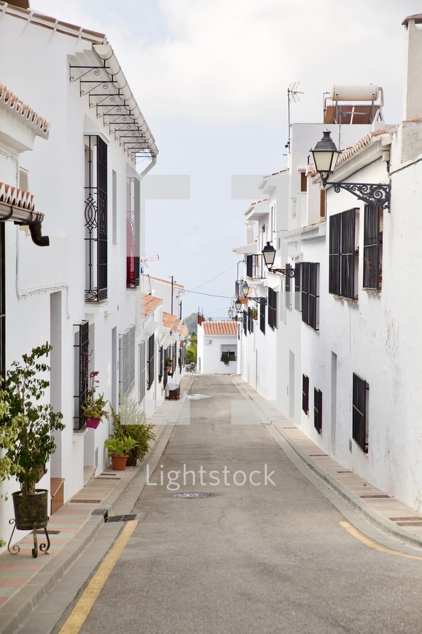 narrow street lined with beautiful white buildings 