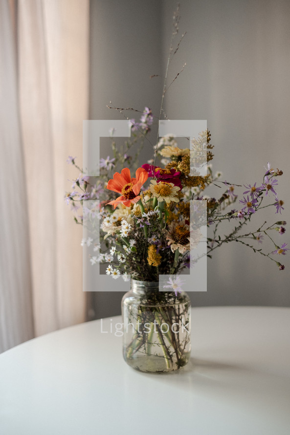 vase of picked flowers on a white table 