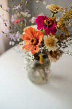 flowers in a jar on white table 