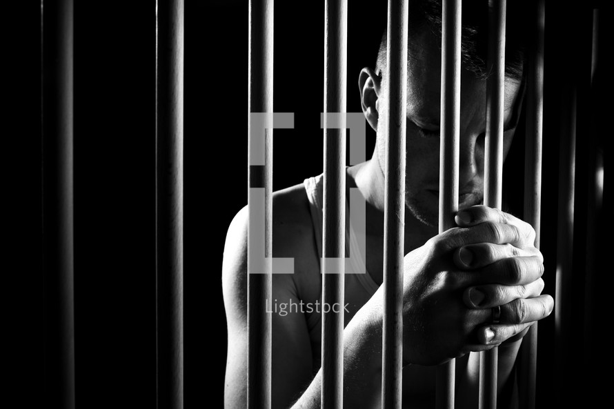 a man holding onto prison bars 