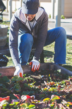 A woman working in a raised garden bed.