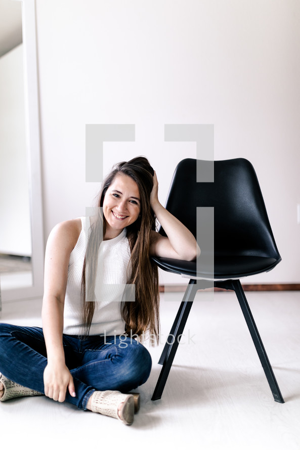 smiling young woman sitting on the floor 
