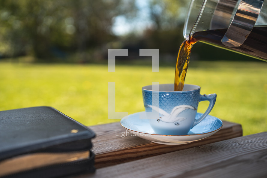 Bible and tea cup outdoors 