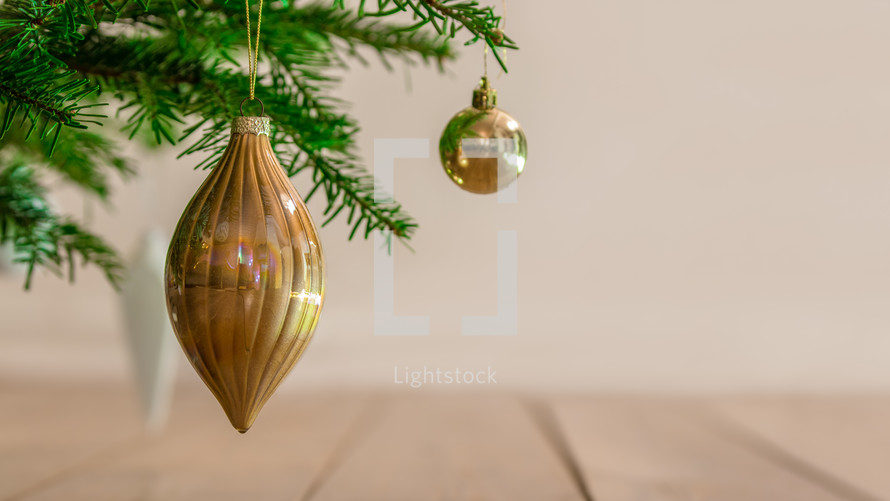 gold ornaments hanging on the branches of a Christmas tree 