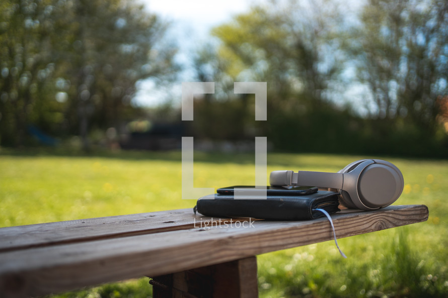 Bible and headphones outdoors 