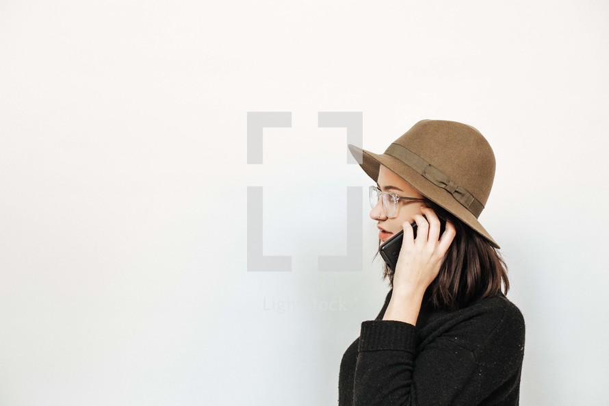 woman in a hat talking on a cellphone 