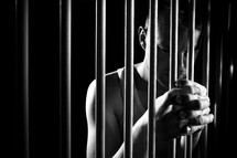 a man holding onto prison bars 