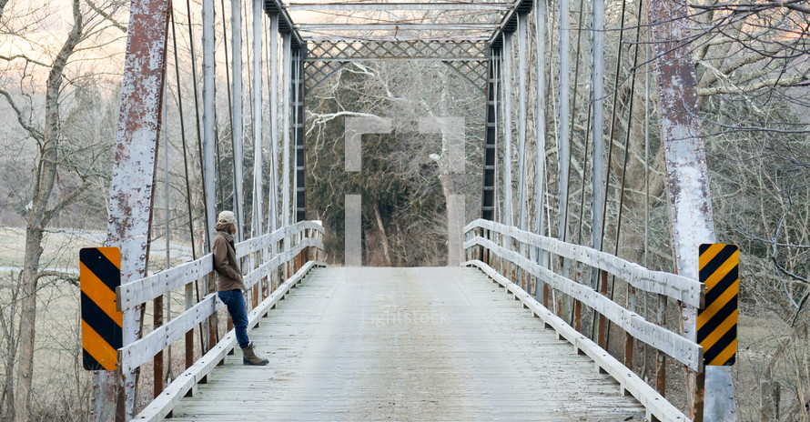 a woman leaning against the side of railings on a bridge 