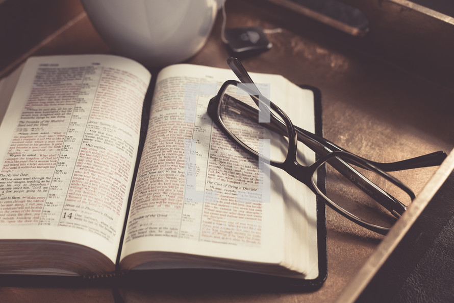 Coffee cup, reading glasses, and an open Bible 