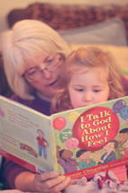 grandmother reading to her granddaughter 