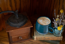 Old fashioned coffee grinder with a mug of coffee 