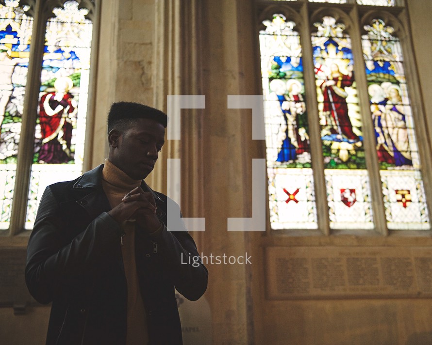 African American man praying in a church 