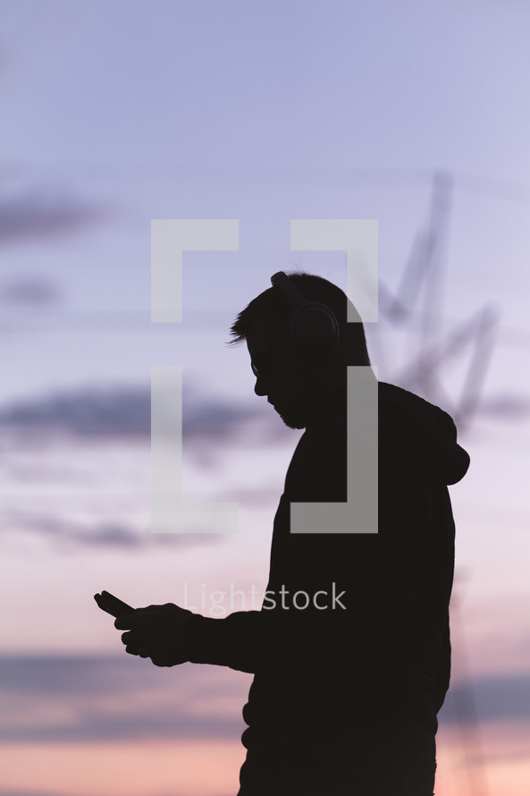 silhouette of a man holding a cellphone 