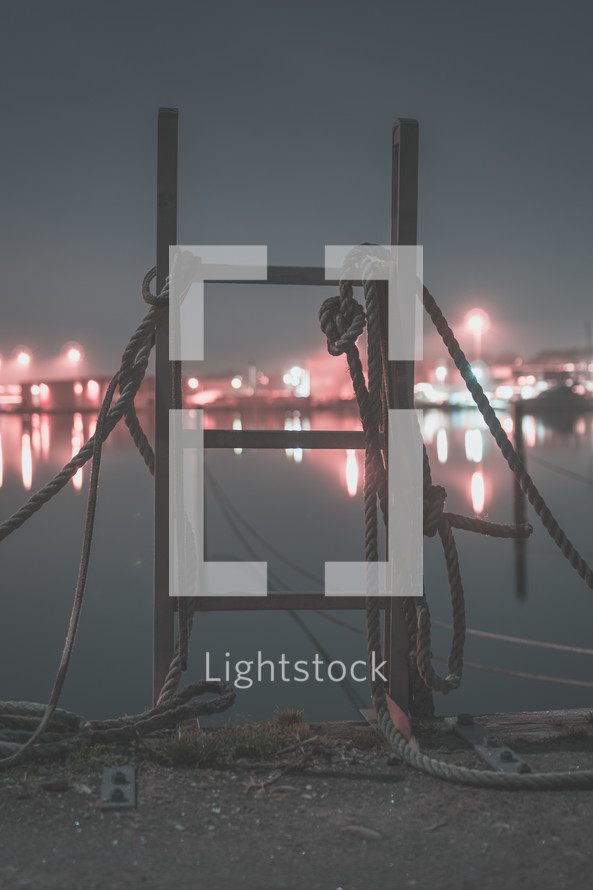 rope on a ladder on a dock at night 