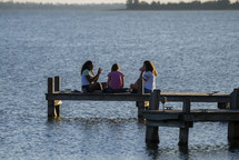 teen girls talking at the end of a dock