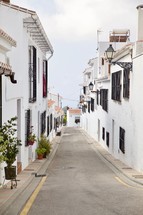 narrow street lined with beautiful white buildings 