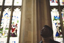 African American man looking up to God in a church 
