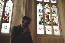 a man in a church with praying hands 