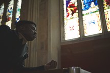 a man in prayer in a church 